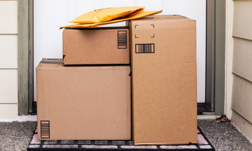 Cardboard boxes delivered on a door step.